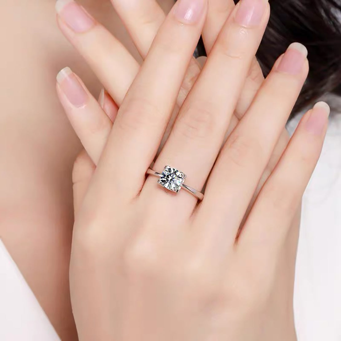 a woman's hand holding a diamond ring